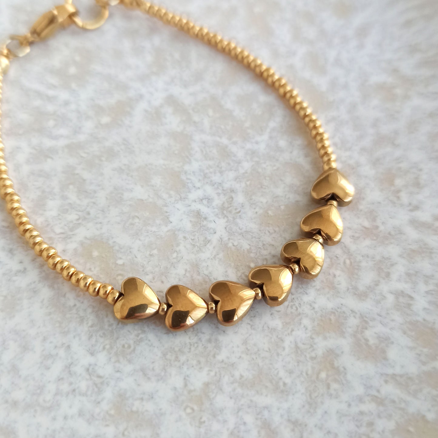 Náramek s pozlacenými srdíčky a rokajlem